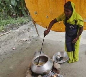 A cook prepares food for free mid-day meal for children, distributed by government-run primary school, at Brahimpur village